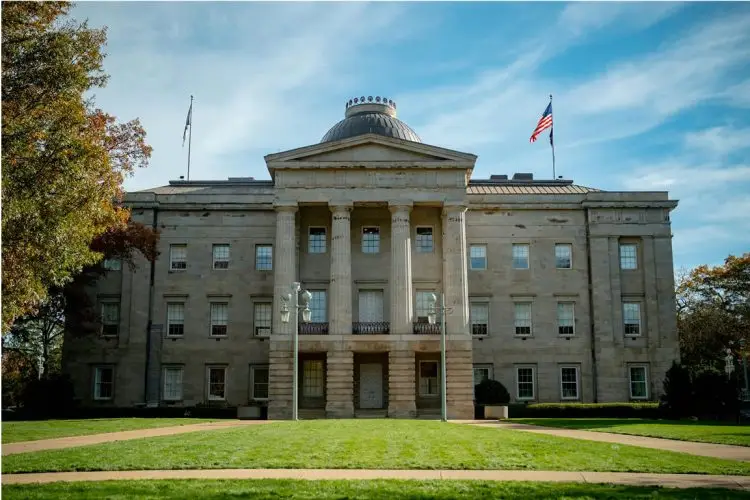 Historic courthouse building with columns and landscaped lawn