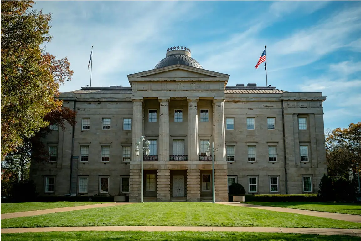 Historic courthouse building with columns and landscaped lawn