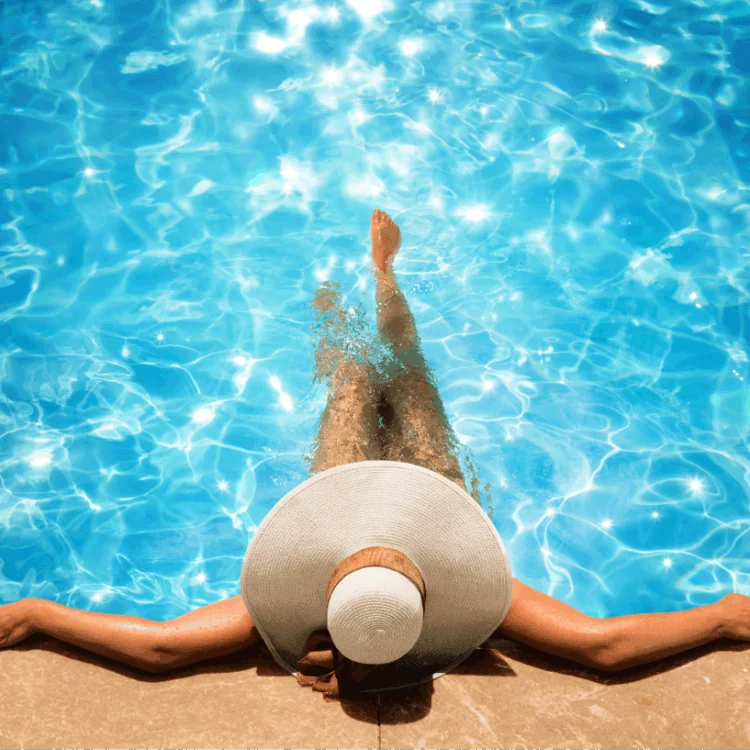 Women relaxing and enjoying a crystal-clear swimming pool on a sunny day