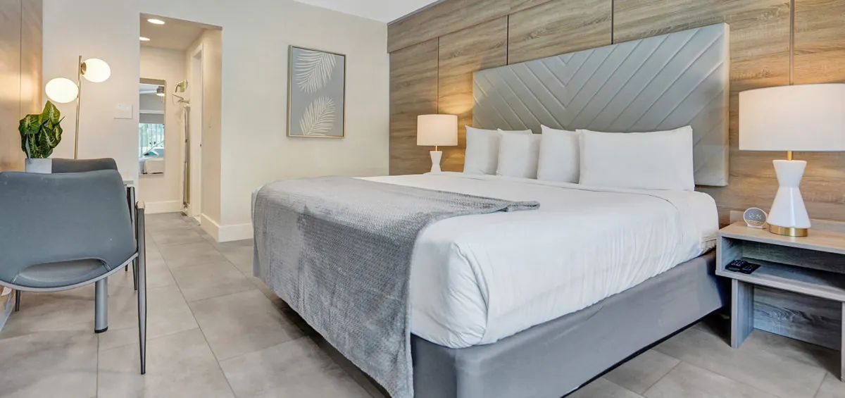 King bed with upholstered headboard, bedside lamps, and seating area