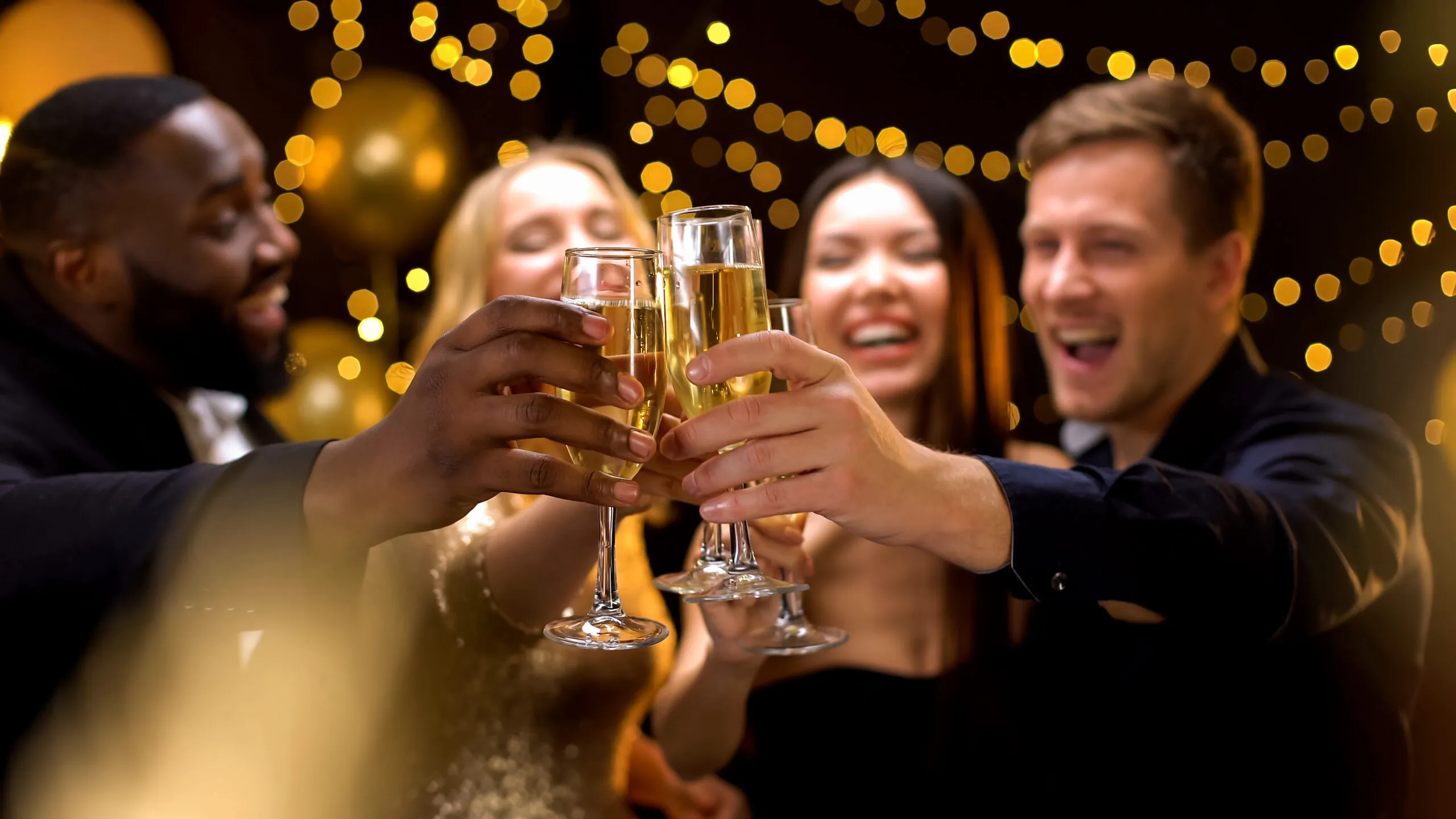 Friends clinking champagne glasses at a festive evening gathering