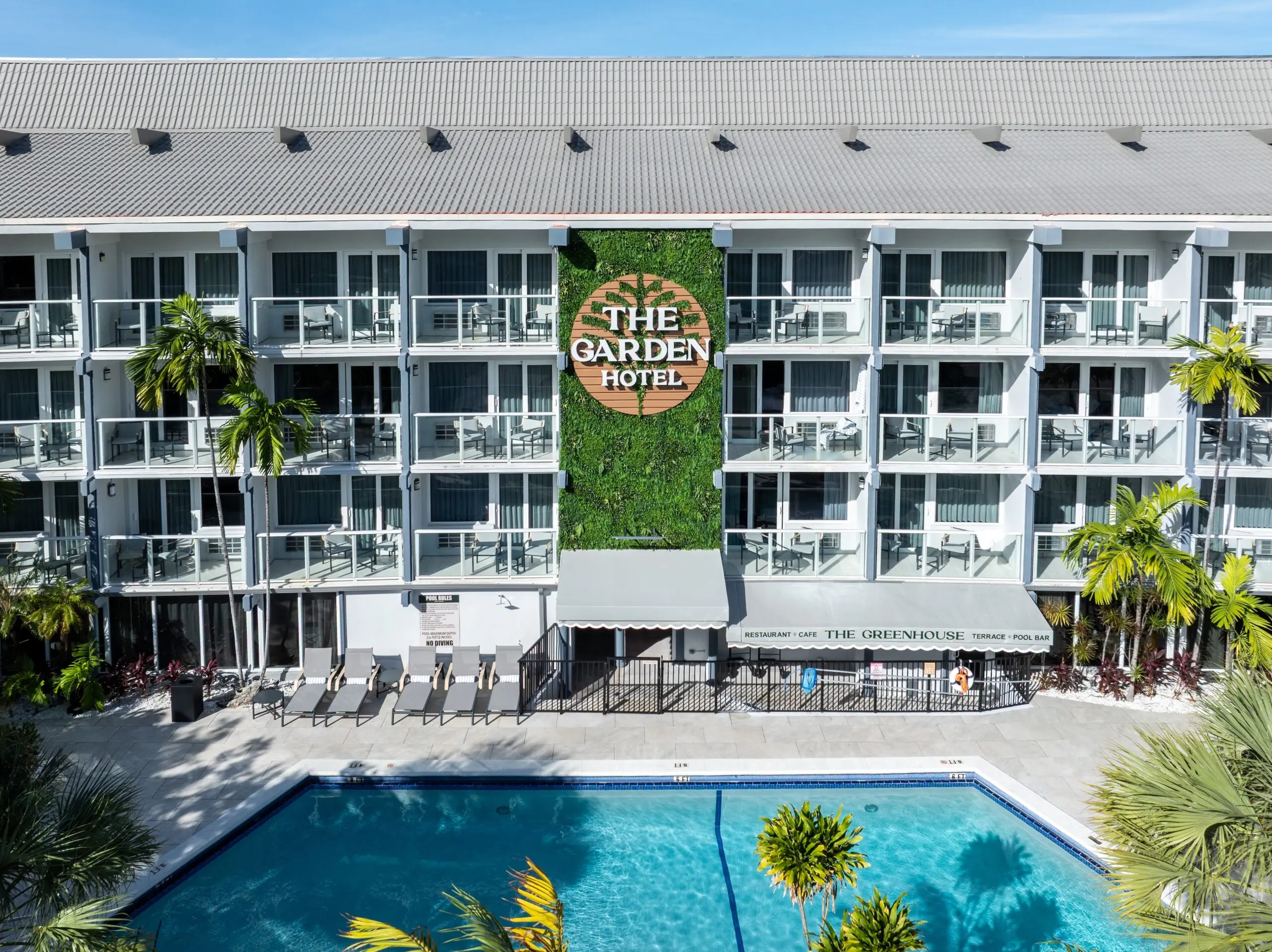 Aerial view of hotel pool deck with sun loungers and balconies