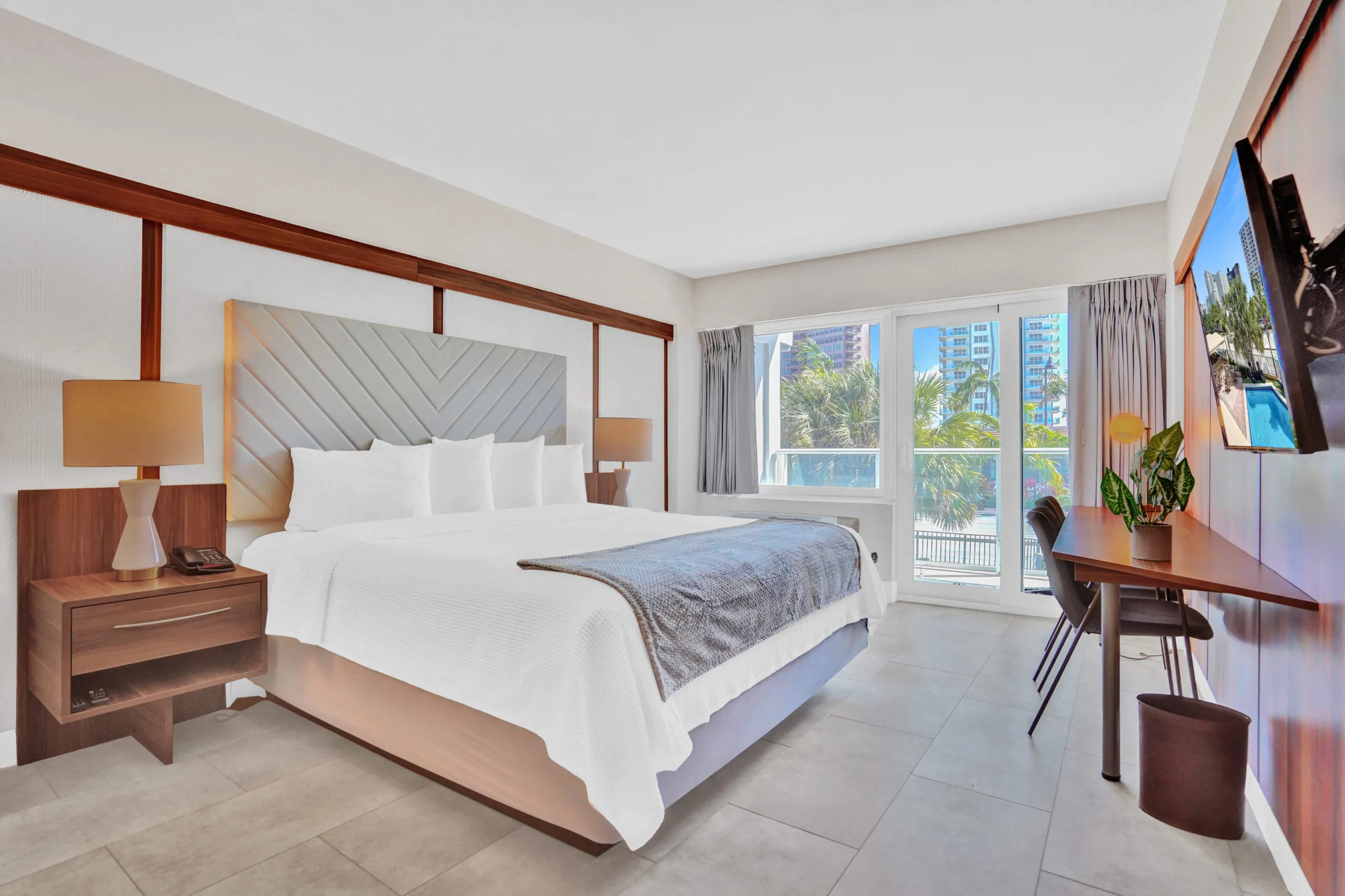 King bed with upholstered headboard, bedside lamps, and desk area