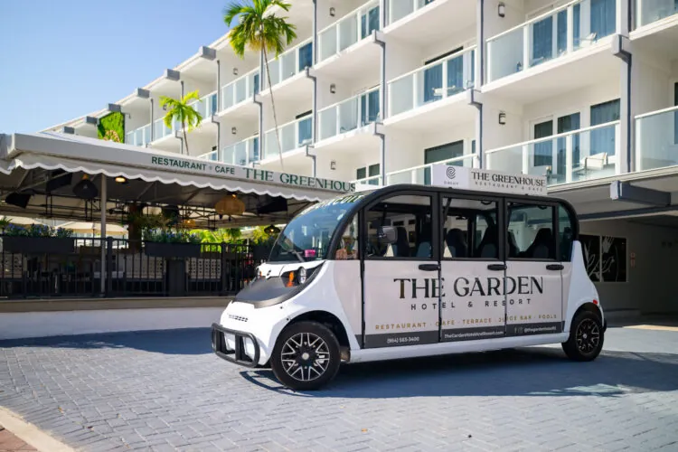 Branded hotel shuttle van parked in front of a modern resort building