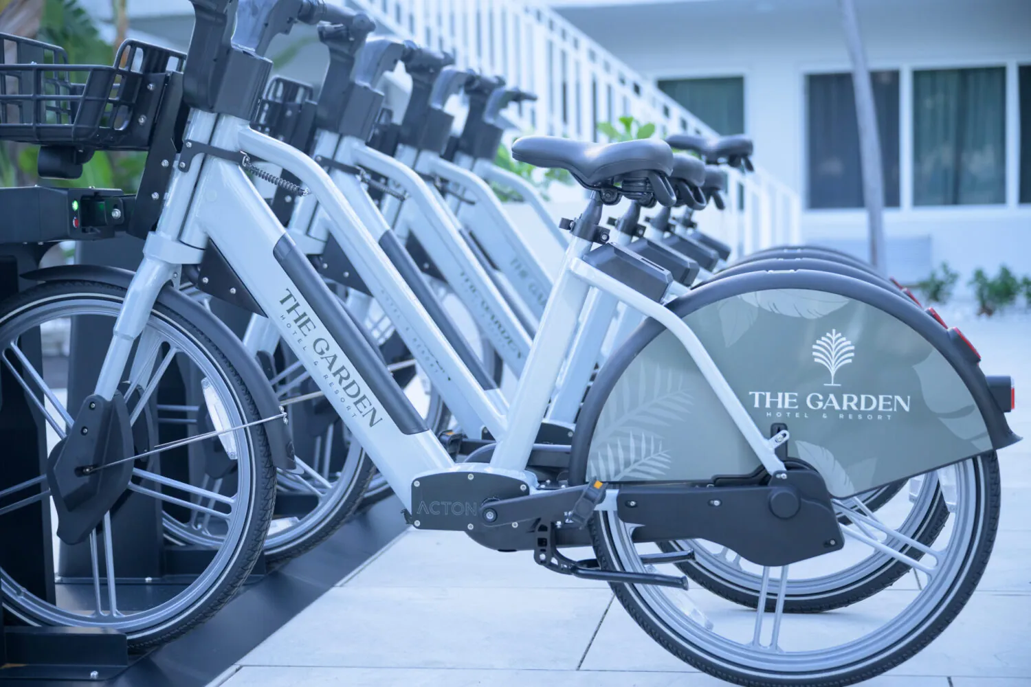 Row of white electric bicycles parked outside a hotel entrance